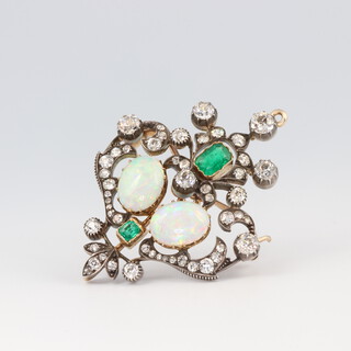 A fine Victorian yellow metal opal, emerald and diamond brooch/pendant comprising 2 oval cut opals each 10mm x 8mm, 2 emerald cut emeralds 0.5ct and 0.15ct and 50 old cut and brilliant cut diamonds approx. 3ct, 13.2 grams, 49mm x 36mm 
