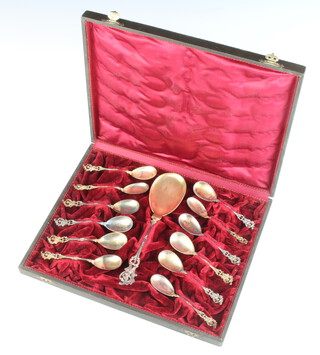 A set of Continental 800 spoons comprising 1 serving spoon and 11 teaspoons with Rococo decoration and figural handles, contained in a fitted velvet box 210 grams 