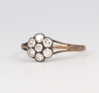 A yellow metal 7 stone diamond daisy ring, 2.4 grams, size R 1/2