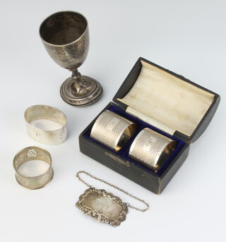 A pair of silver engine turned napkin rings Birmingham 1943, 2 others, a presentation trophy (a/f) and a spirit label 182 grams 