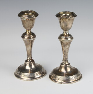 A pair of silver tapered candlesticks with reeded decoration, rubbed marks, 16cm 