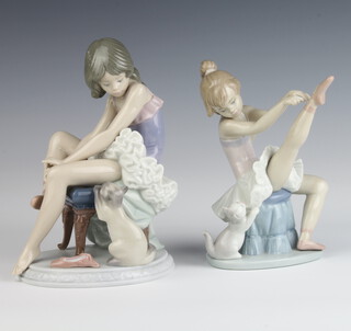 A Lladro figure of a girl ballet dancer sitting on a pouffe with a kitten at her side 6614 17cm, a ditto sitting on a stool 5660 18cm 