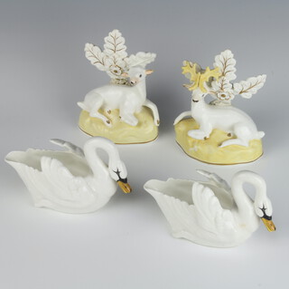 A pair of Victorian porcelain figures of swans retailed by Thomas Goode and Co 9cm together with a pair of 19th Century figures of deers before bocage 12cm (1 stuck) 