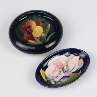 A Moorcroft oval pin tray with blue ground decorated a magnolia 11cm, ditto circular bowl decorated an anemone 11cm 