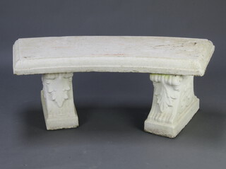 A white painted reconstituted stone crescent bench raised on scroll supports 47cm h x 120cm w x 41cm d 