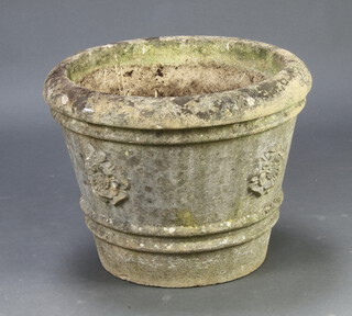 A circular well weathered reconstituted stone garden urn with tudor rose decoration 44cm h x 55cm diam. 