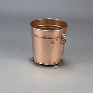 A cylindrical copper and brass twin handled coal bin with lion mask ring handles, raised on paw supports 30cm h x 28cm diam. 