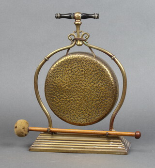An Edwardian brass tea gong with beater 29cm h x 27cm x 7cm 