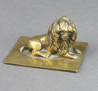 A gilt metal paperweight of a seated dog  4cm x 7cm x 5cm 