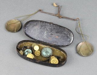 A 19th Century gold scales together with 13 various weights contained in an oval pressed metal box 
