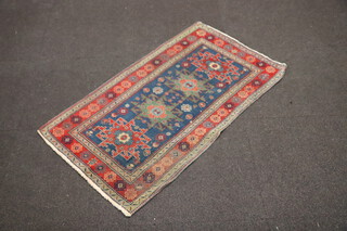 A blue, green and brown ground Caucasian style rug with 4 stylised medallions to the centre within a 3 row border 111cm x 64cm 
