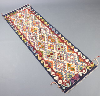 A white, green and black ground Chobi Kilim runner with 7 diamonds to the centre flanked by 2 rows of stylised medallions 203cm x 66cm