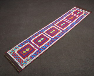 A blue, white and red ground Suzni Kilim runner with 6 rectangular panels to the centre 303cm x 67cm 