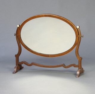A 19th Century oval bevelled plate dressing table mirror contained in a mahogany swing frame 48cm h x 55cm w x 20cm d