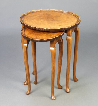 A nest of 2 Queen Anne style quarter veneered coffee tables with pie crust edge, raised on cabriole supports, the largest being oval 51cm h x 42cm w x 35cm d and the smaller circular 48cm h x 30cm diam.  