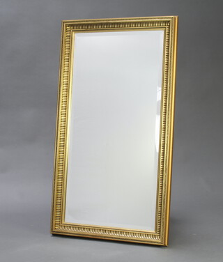 A 20th Century rectangular bevelled plate mirror contained in a decorative gilt frame 103cm x 57cm 
