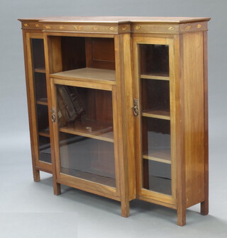 An Edwardian Art Nouveau walnut breakfront display cabinet fitted a shelf above a cupboard enclosed by glazed panelled doors, flanked by a pair of cupboards enclosed by glazed panelled doors raised on square supports 117cm h x 142cm w x 30cm d 
