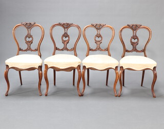 A set of 4 Victorian walnut balloon back chairs with carved splats and overstuffed seats raised on French cabriole supports 87cm h x 45cm w x 40cm d (seat 21cm x 28cm)  