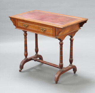 A Victorian aesthetic style walnut writing table with inset writing surface, fitted a frieze drawer, raised on turned supports with H framed stretcher and ceramic casters 77cm h x 90cm w x 52cm d 