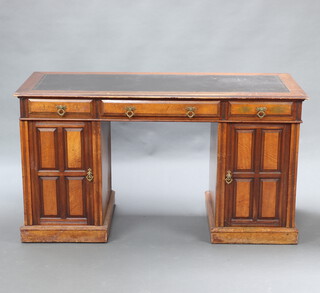 A Victorian aesthetic movement walnut pedestal desk with inset writing surface, fitted 1 long and 2 short drawers with replacement handles, the pedestals fitted cupboards enclosed by panelled doors, 75cm h x 139cm w x 60cm d 