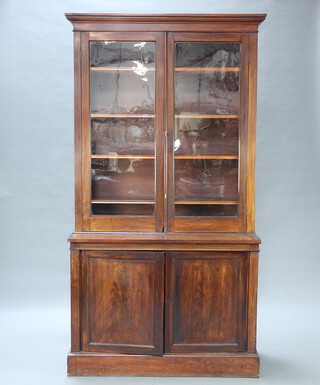 A Victorian mahogany bookcase on cabinet, the upper section with moulded cornice the interior fitted adjustable shelves enclosed by glazed panelled doors, the base fitted a cupboard enclosed by panelled door, raised on a platform base 220cm h x 116cm w x 47cm d 