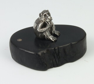 A Zimbabwean cast silver figure of a seated baboon raised on a hardwood base 3cm 