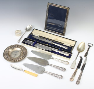 A George III silver fiddle pattern table spoon, a napkin ring, butter knife and a rectangular silver photograph frame, weighable silver 104 grams, together with minor plated wares