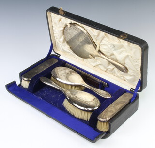 A silver cased brush set comprising 2 hair brushes, 2 clothes brushes, a hand mirror and comb, London 1920, engraved with monogram, cased 