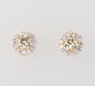 A pair of 18ct white gold pale yellow diamond ear studs surrounded by brilliant cut diamonds, 2 grams 