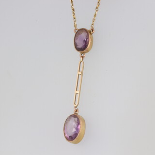 A yellow metal double amethyst drop pendant on a yellow metal chain 3.6 grams 