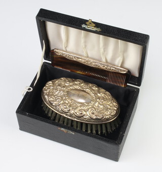 A cased silver mounted repousse hair brush and comb Birmingham 1979, cased and unused 