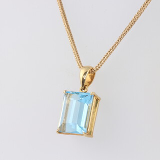 An 18ct yellow gold mounted rectangular cut aquamarine pendant 15mm x 11mm on a yellow metal chain 50cm chain weight 5.9 grams, pendant 4.7 grams