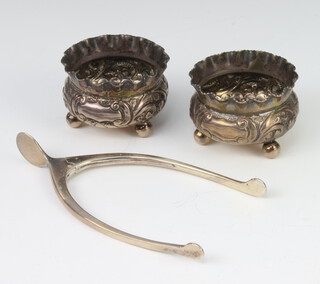 A pair of silver wishbone sugar nips Birmingham 1928, a pair of repousse salts 58 grams 