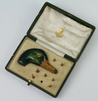 An Edwardian enamelled parasol handle in the shape of a ducks head with 7 umbrella tips in a fitted case (lacking 1 tip)