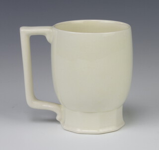 A Wedgwood Keith Murray cream glazed mug on a faceted base impressed marks, 10cm