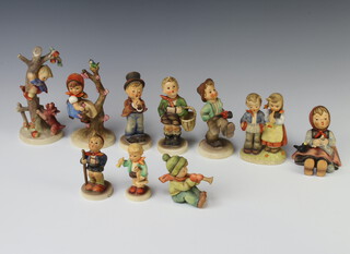 Ten Hummel figures comprising boy with recorder 7cm, boy with shopping basket 12cm, boy with toy horse 8.5cm, boy with top hat 35 11cm, boy with little hiker 10cm, girl and boy playing instruments 195 10cm, apple tree girl 747 15cm, happy pastime 9cm, boy with umbrella 109 12cm and boy up a tree with a dog at his feet 56 16cm 