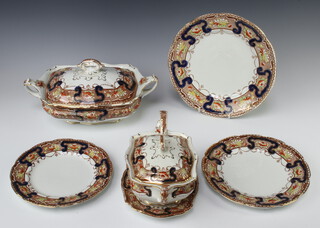 An Edwardian dinner service with ochre, red and blue decoration comprising 10 small plates, 11 medium plates, 11 dinner plates, 4 graduated meat plates, 2 large vegetable tureens, 2 sauce tureens with ladles and stands, 2 dishes, minor china 