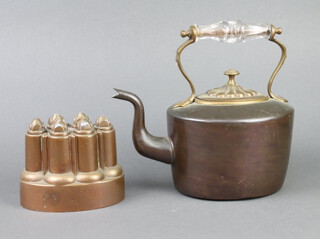 A 19th Century Benham and Froud oval copper jelly mould marked 629 and stamped with the Orb and Cross mark, 12cm h x 14cm w x 9cm d, together with a Victorian oval copper kettle with glass insulated handle 25cm h x 16cm w x 12cm d   