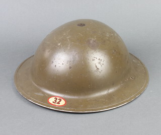 A World War Two steel helmet marked 32 