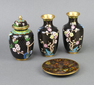 A Japanese black ground cloisonne enamelled urn and cover with floral decoration 15cm h x 5cm diam., a pair of club shaped urns decorated trees 15cm x 4cm and a circular dish 2cm h x 13cm  diam. 