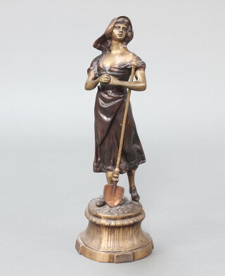 A bronze figure of a standing Continental lady gardener with spade, raised on a circular base 69cm h x 21cm 