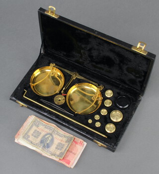 A gilt metal gold balance together with 16 weights contained in a plush box together with 2 central bank of Barbados one dollar bills, an Eastern Caribbean Central Bank one dollar bill, 2 Italian 1000 lira notes and a Netherlands 2 1/2 Gulden note