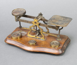 A set of brass postage scales on mahogany base 9cm h x 21cm w x 12cm d 
