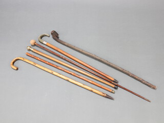 A malacca walking cane with silver band and horn handle, a shillelagh style walking stick and 4 other walking sticks 