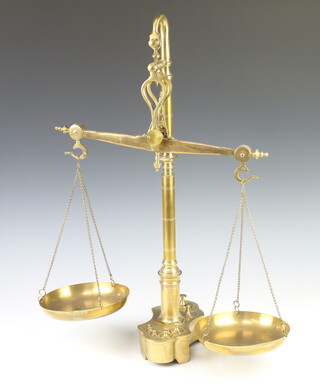 A set of unmarked brass scales the shaped base fitted 8 weights 61cm h x 37cm w x 18cm d 
