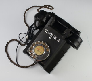 A black Bakelite wall mounted telephone, the hand receiver marked 164 53, the reverse marked 311F E53/2A 