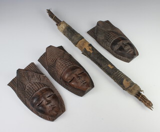 Three African carved hardwood masks 24cm x 13cm, 24cm x 12cm and a quiver of various hardwood tipped arrows 