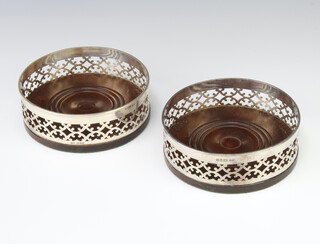 A pair of pierced silver coasters with hardwood bases London 1973, 13cm 