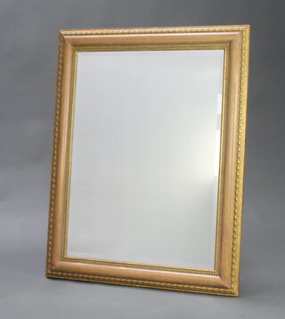 A 20th Century rectangular bevelled plate wall mirror contained in a decorative gilt frame 75cm h x 94cm w 