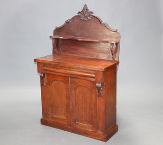 A Victorian mahogany chiffonier, the carved raised back fitted a shelf, the base fitted a secret drawer above cupboard enclosed by a pair of arched panelled doors 149cm h x 89cm w x 36cm d 
